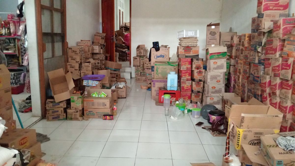 Ruang stok Toko Ana penuh kardus sembako dari lantai sampai atas